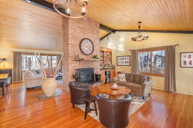 living room with beam ceiling, wooden ceiling, a notable chandelier, light hardwood / wood-style floors, and a fireplace