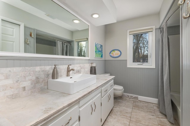 full bathroom with tile patterned flooring, shower / bath combination with curtain, vanity, and toilet