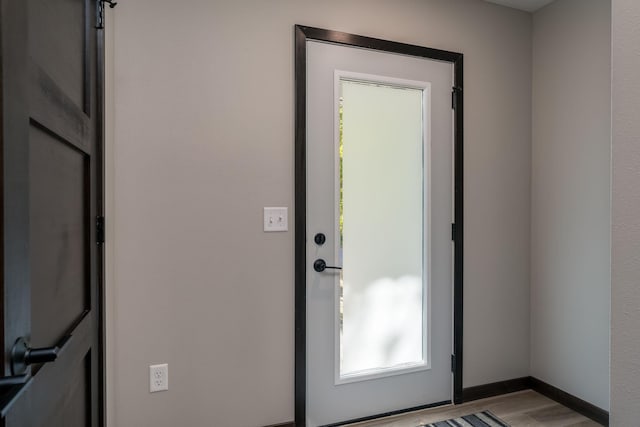 doorway featuring light wood-type flooring and baseboards