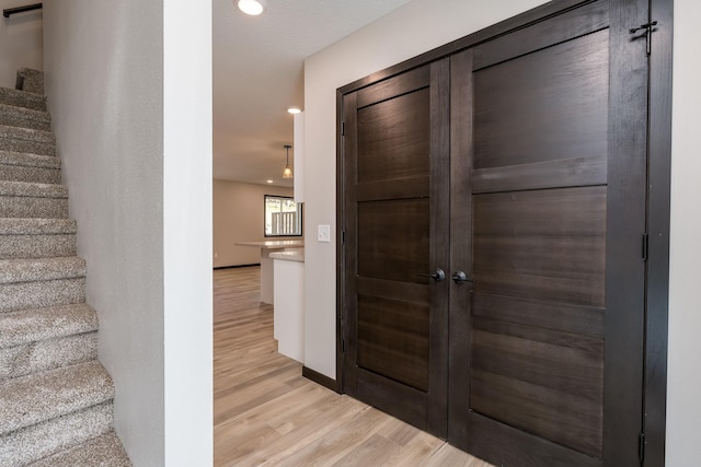 interior space with recessed lighting, baseboards, stairs, and light wood finished floors