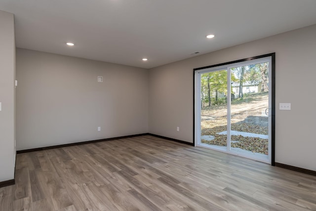 unfurnished room with recessed lighting, light wood-style flooring, visible vents, and baseboards