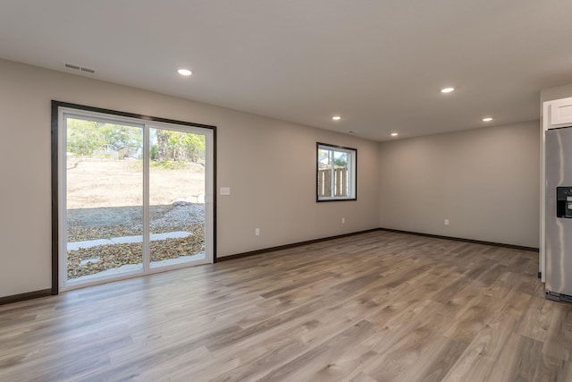 unfurnished living room featuring light wood-type flooring, visible vents, baseboards, and recessed lighting