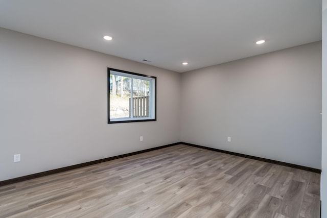 spare room featuring recessed lighting, baseboards, and light wood finished floors