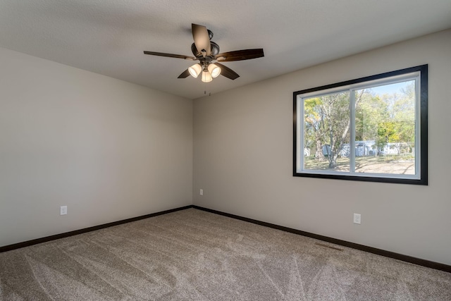 unfurnished room featuring baseboards, carpet, and a ceiling fan