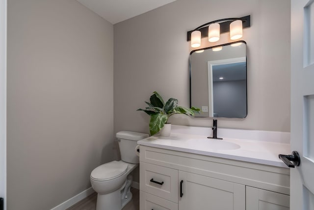 3104 Scotch Ln, Mankato, MN 56001 - half bathroom with toilet, vanity, wood finished floors, and baseboards
