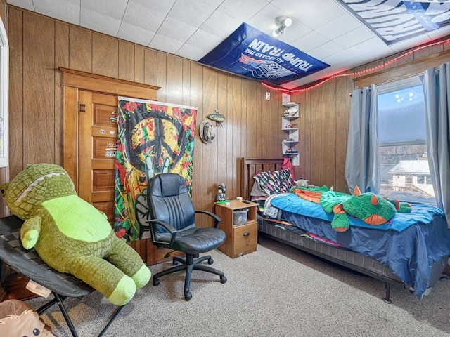 carpeted bedroom with wood walls