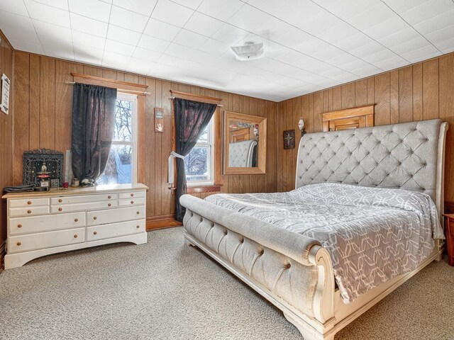 bedroom with carpet and wood walls