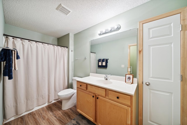 bathroom with toilet, vanity, a textured ceiling, and hardwood / wood-style flooring