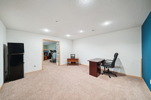 carpeted home office with a textured ceiling