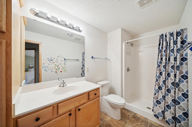 bathroom featuring walk in shower, tile patterned floors, a textured ceiling, toilet, and vanity