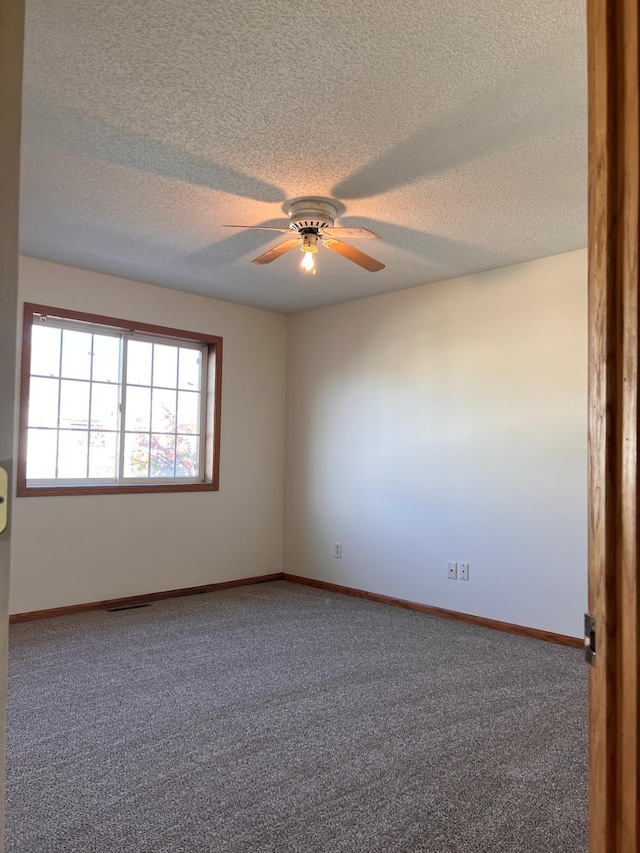 unfurnished room with carpet flooring, ceiling fan, and a textured ceiling