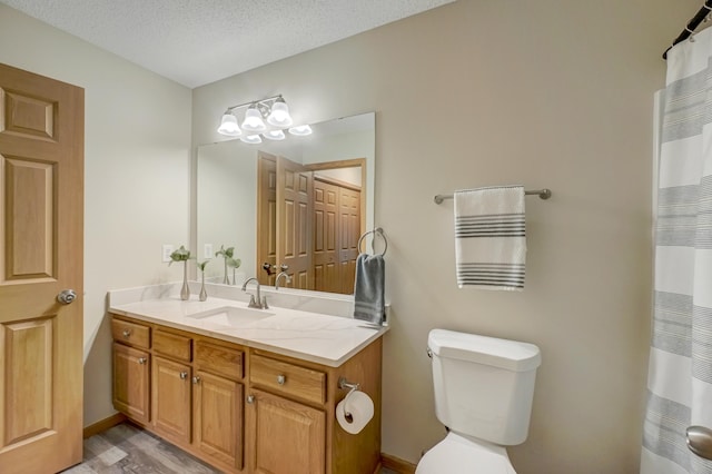 bathroom with vanity, hardwood / wood-style floors, a textured ceiling, and toilet