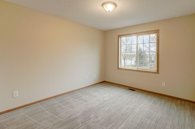 carpeted spare room with a textured ceiling