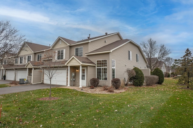 view of property with cooling unit, a front lawn, and a garage