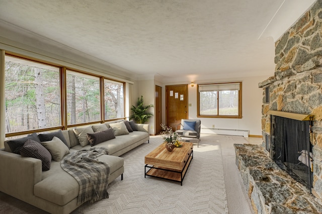 living room featuring a fireplace, a textured ceiling, baseboard heating, and a healthy amount of sunlight