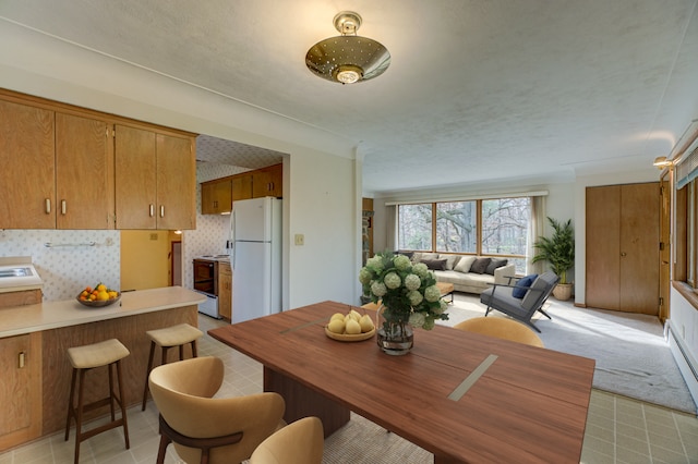 dining space with light carpet and a textured ceiling