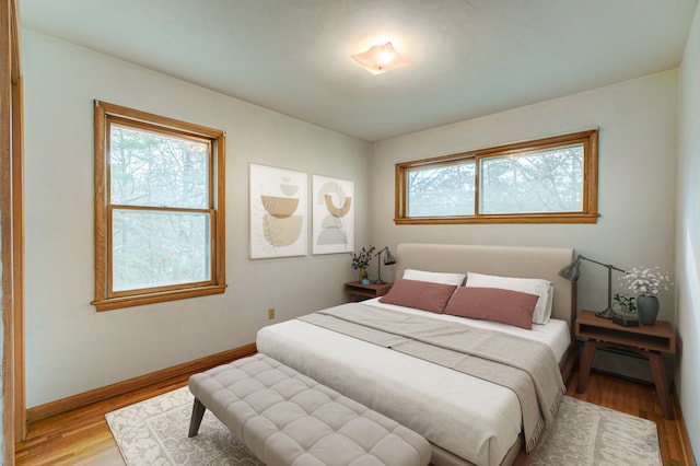 bedroom with multiple windows and light wood-type flooring