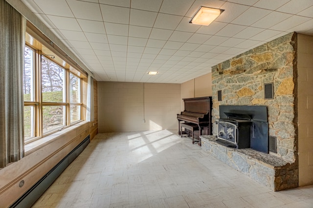 living room with baseboard heating and a wood stove