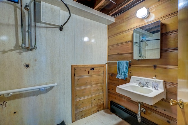 bathroom featuring sink and wooden walls