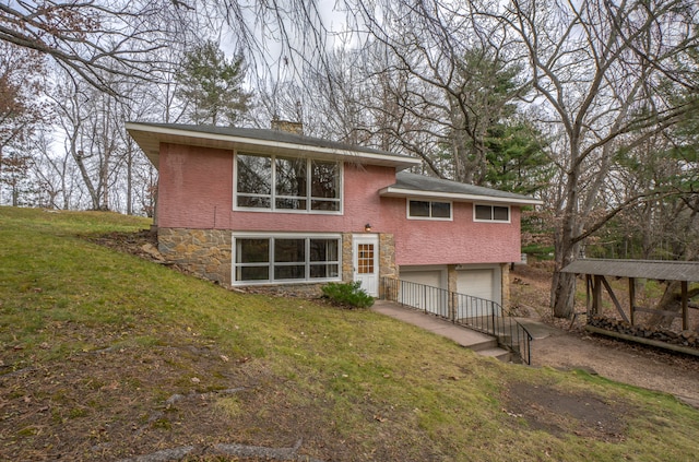 back of house with a lawn and a garage