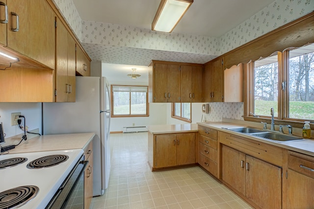 kitchen featuring white range with electric cooktop, kitchen peninsula, sink, and a baseboard radiator