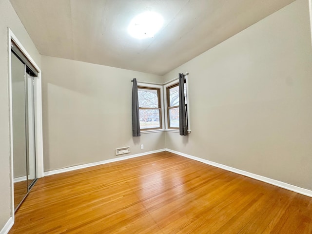 unfurnished bedroom with a closet and wood-type flooring