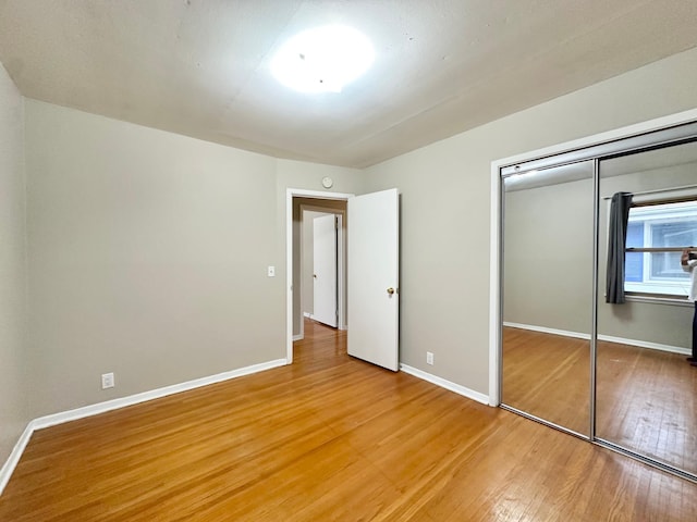 unfurnished bedroom featuring hardwood / wood-style floors and a closet