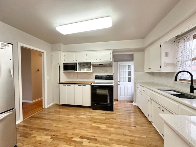 kitchen featuring white cabinetry, sink, tasteful backsplash, light hardwood / wood-style flooring, and appliances with stainless steel finishes