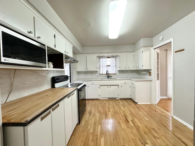 kitchen featuring white cabinets, sink, decorative backsplash, light wood-type flooring, and black / electric stove