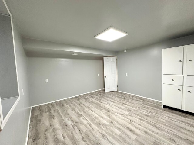 basement with light hardwood / wood-style flooring