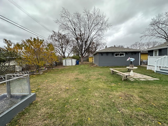 view of yard featuring a deck and a storage shed