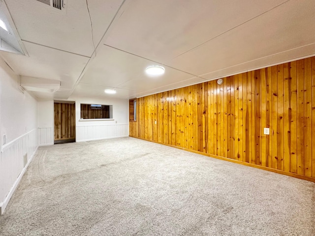 basement with carpet flooring and wooden walls