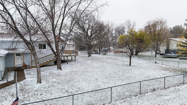 yard layered in snow with a trampoline