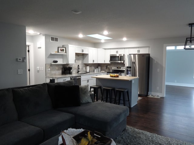 living room with dark hardwood / wood-style floors and sink