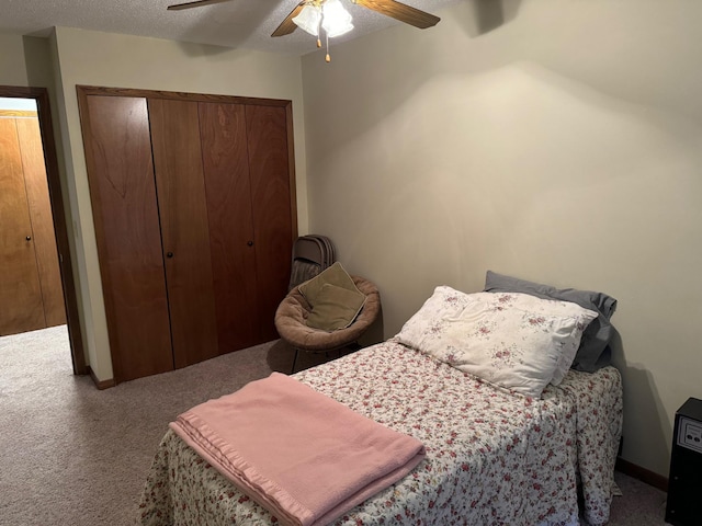 carpeted bedroom featuring ceiling fan and a textured ceiling