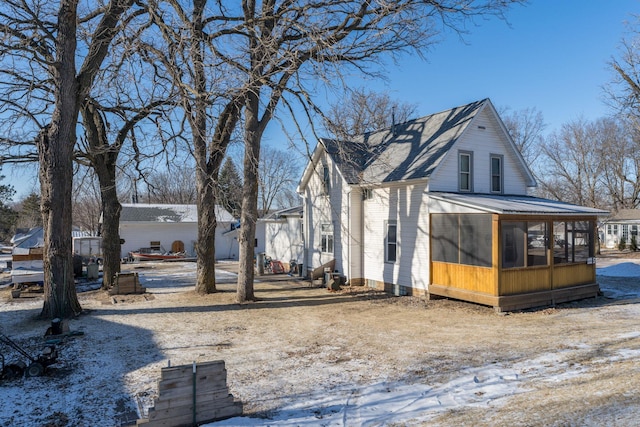 snow covered property featuring a sunroom