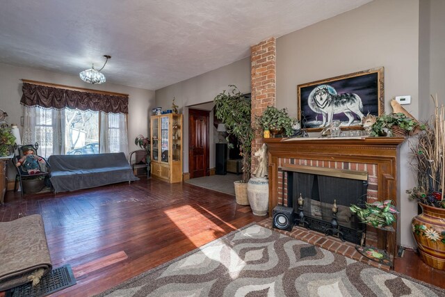 living room featuring dark hardwood / wood-style flooring and a brick fireplace