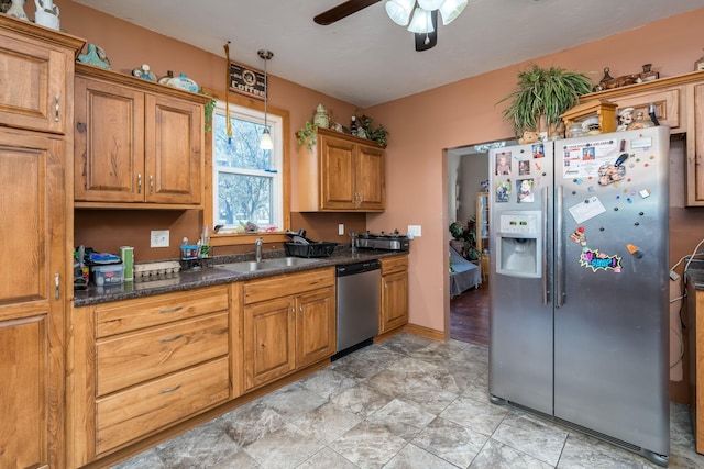 kitchen featuring decorative light fixtures, sink, dark stone countertops, ceiling fan, and stainless steel appliances