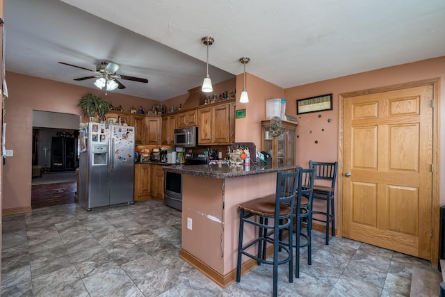 kitchen with appliances with stainless steel finishes, pendant lighting, a kitchen breakfast bar, ceiling fan, and kitchen peninsula