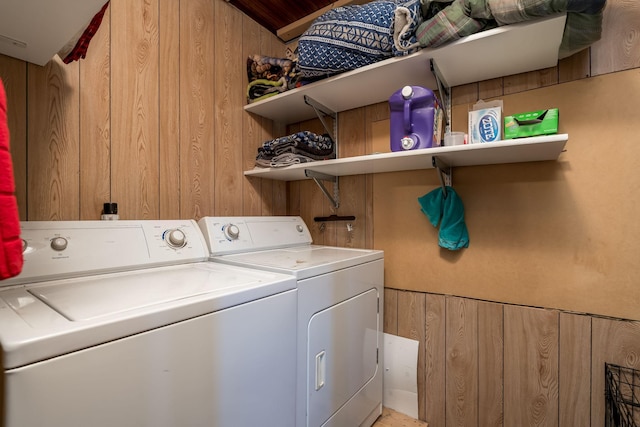 laundry room with wooden walls and washing machine and clothes dryer