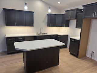 kitchen featuring sink, a kitchen island, and pendant lighting