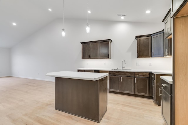 kitchen with dark brown cabinetry, a kitchen island, visible vents, and a sink