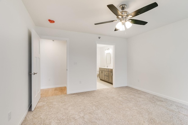 unfurnished bedroom with light carpet, baseboards, a ceiling fan, and ensuite bathroom