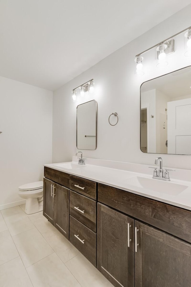 full bath with double vanity, tile patterned flooring, toilet, and a sink