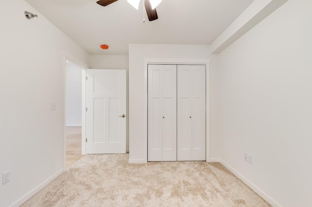 unfurnished bedroom featuring carpet floors, baseboards, and a closet