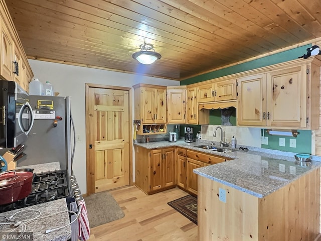 kitchen with light wood finished floors, a sink, wooden ceiling, light stone counters, and appliances with stainless steel finishes