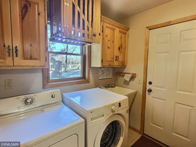 laundry area featuring washer and dryer, cabinet space, and a textured ceiling