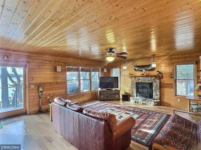 living room with wooden walls, wood ceiling, and a healthy amount of sunlight