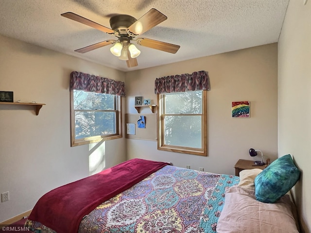 bedroom with a textured ceiling and a ceiling fan