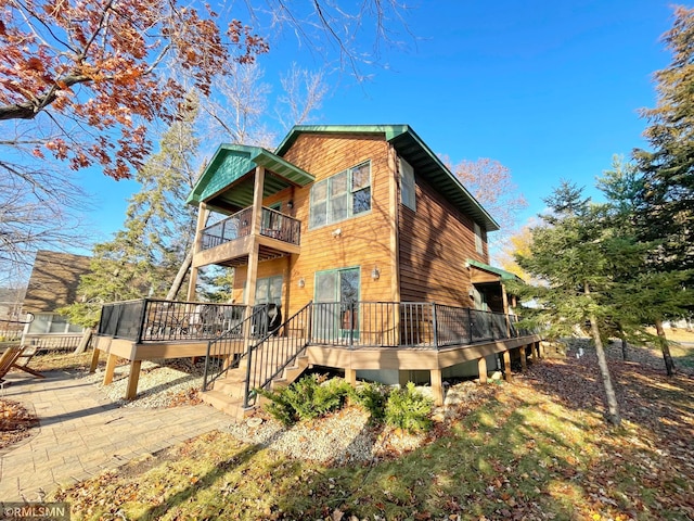 back of property featuring a deck and a balcony